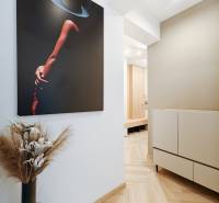 2 szobás lakás belső tere fa dekorációjú padlóval és modern műalkotással.