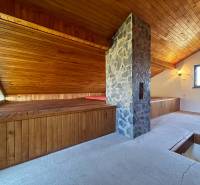 Padlásszoba fa burkolattal és kő kéménnyel a házikóban.