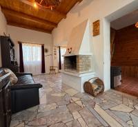 Kandallós ház, kényelmes kanapéval és fa mintázatú padlóval.