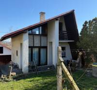 Házikó Aranyosmaróton fa kerítéssel, gyepes udvarral és körülötte fákkal.