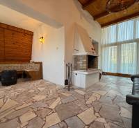 Egy kandallóval és ülőhellyel rendelkező faház belső tere, kőpadlóval.