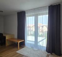 Nappali szoba asztallal és fa dekorpadlóval egy háromszobás lakásban.