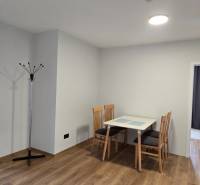 Étkező sarok asztallal és székekkel, fa dekorációjú padló egy háromszobás lakásban.