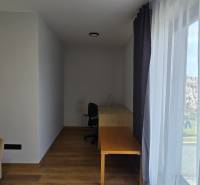 Szoba egy háromszobás lakásban, fa dekorációjú padlóval, asztallal és kanapéval.