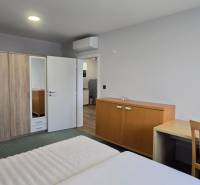 Hálószoba egy háromszobás lakásban franciaággyal, szekrénnyel és asztallal.