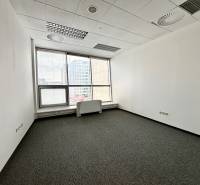 Üres iroda szőnyegpadlóval és nagy ablakokkal.