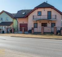 Családi ház Poprádon, két emelettel, garázzsal és erkéllyel, téglából készült kerítéssel.