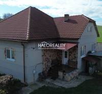 Családi ház Rimajánosiban piros tetővel és vidéki környezettel.