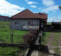 Családi ház Rimajánosiban, zöld gyepes telken, kerítéssel.