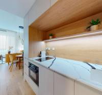 Konyha fehér márvány pulttal és fa dekorációjú padlóval egy egyszobás lakásban.