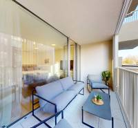 Erkély ülőhellyel, kilátás a környező épületekre, üvegajtó az egyszobás lakásba.