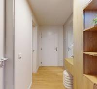 Folyosó egy egyszobás lakásban, fehér ajtókkal és fa dekorációjú padlóval.