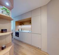 Konyha egy egyszobás lakásban fehér szekrényekkel és fa dekorral.