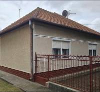 Családi ház Radaván, a Fő utcán, piros tetővel és fehér zsalugáterekkel.