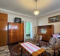 Nappali egy családi házban szőnyeggel, régebbi bútorokkal és csillárral.