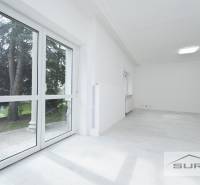 Világos szoba nagy ablakokkal és fa dekorációjú padlóval egy 4 szobás lakásban.