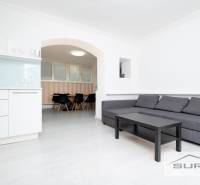 Nappali egy négy szobás lakásban konyhasarokkal és ülőgarnitúrával.