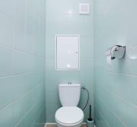 WC egy háromszobás lakásban világoskék csempével és világos színű padlóval.