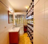 Fürdőszoba családi házban mosdóval, zuhanyzóval és csempével.