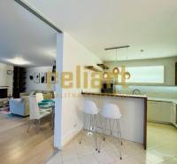 Konyha és nappali családi házban bárpulttal és székekkel.