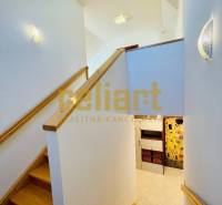 Családi ház belső tere lépcsővel és fa dekorációjú padlóval.