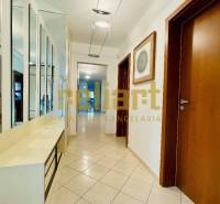 Folyosó egy családi házban csempével, tükrös fallal és faajtókkal.