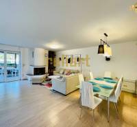 Családi ház belső tere kandallóval, fa dekorációjú padlóval és étkezőasztallal.