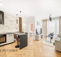 Nappali és konyha egy 4 szobás lakásban, fa dekorációjú padlóval és világos díszítéssel.