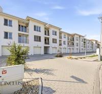 Dunaszerdahelyen található fehér épületek és parkolóhelyek együttese, ideális egy 4 szobás lakás számára.