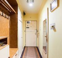 Előszoba egy 3 szobás lakásban fogassal, tükörrel és egyszerű világítással.