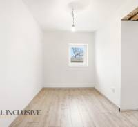 Szoba egy családi házban fehér falakkal és fa dekorációjú padlóval.