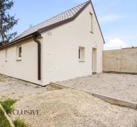 Családi ház Alsóvámoson fehér homlokzattal és ferde tetővel, kavicsos telken.