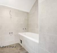 Fürdőszoba családi házban káddal és világos csempékkel a falakon.