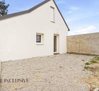 Családi ház Alsóvámoson fehér homlokzattal és kavicsos udvarral.