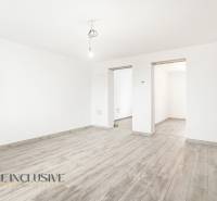 Fehér szoba egy családi házban, fa dekorációjú padlóval és csupasz izzóval.