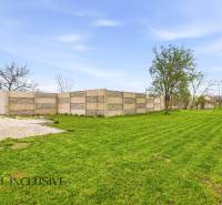 A Dolný Bar-i családi ház kertje gyepes és betonkerítéssel van körülvéve.