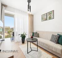 Nappali egy 4 szobás lakásban erkéllyel, kanapéval és fa dekorációjú padlóval.