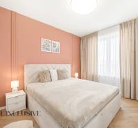 Hálószoba narancssárga fallal és fa mintázatú padlóval egy 4 szobás lakásban.