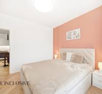 Hálószoba egy 4 szobás lakásban, fa dekorációjú padlóval és meleg tónusokkal.