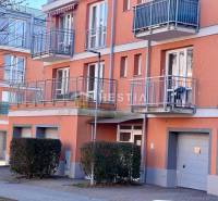 A kép egy lakóház külsejét ábrázolja erkélyekkel és garázsokkal egy egyszobás lakásban.