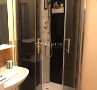 Fürdőszoba zuhanyzóval és mosdóval egy kétszobás lakásban.