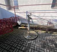 Betonszőnyegen lévő vízpumpa az épület mellett a Szenicei Gasztrótérben.