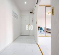 Világos folyosó csempével egy egyszobás lakásban. Belépés a nappaliba.