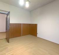 Szoba egy családi házban, fa dekoros padlóval és fa burkolatú falakkal.