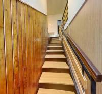 Fa dekorációjú lépcső, amely az emeletre vezet egy családi házban.