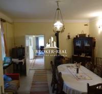 Ebédlő egy családi házban, fa bútorokkal, televízióval és bejárattal egy másik helyiségbe.