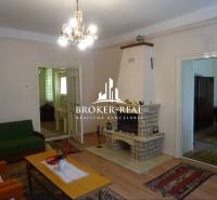 Nappali egy családi házban kandallóval, fa hatású padlóval és csillárral.