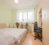 Hálószoba családi házban fa dekor padlóval, ággyal és íróasztallal.