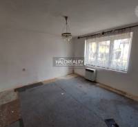 Szoba szőnyeggel, fehér falakkal és nagy ablakkal, felújításra alkalmas; Lakóingatlanok.