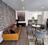 Nappali egy családi házban kényelmes kanapéval és étkezőszékekkel.